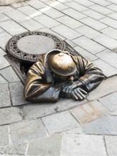 Gaffer (Cumil), bronze sculpture of a worker looking out of a manhole in Bratislava, Slovakia