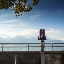 A telescope stands on the lakeside walkway in Vevey, Switzerland, overlooking Lake Genova. The