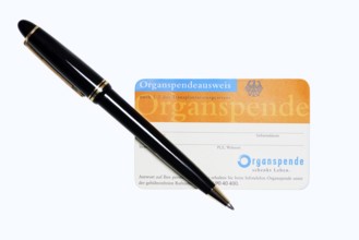 Organ donor card with biros on white background, symbolic image of organ donation