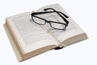 Reading glasses and book on a white background