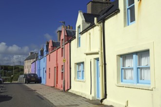 Brightly coloured house facade in sunny weather along a quiet street, Scalloway, Shetland Islands,