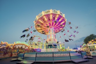 Radiant carousel under the night sky at a funfair, chain carousel, spring festival, Cannstatter