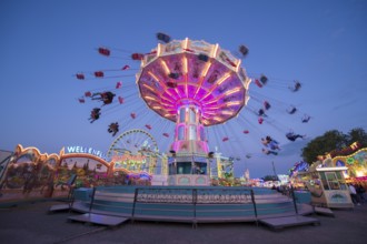 Colourful carousel in motion at a night fair, chain carousel, spring festival, Cannstatter
