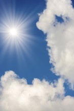 Symbolic image, global warming, heat, bright sunshine next to fluffy clouds in a clear blue sky,