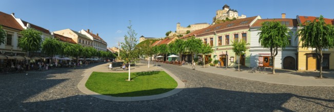 Peace Square with cafés in the old town centre of Trencin, Trencin Castle in the background,