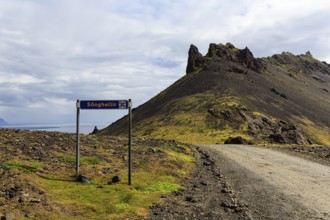 Gravel road with sign for place of interest, lava cave, Sönghellir lava tube, Stapafell mountain,
