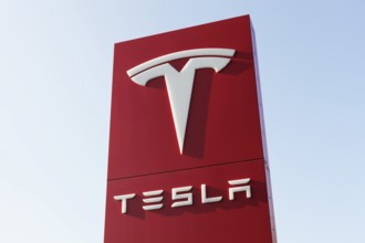 Tesla, pillar with logo in front of Tesla repair shop, US car manufacturer for electric cars,
