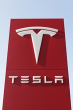 Tesla, pillar with logo in front of Tesla repair shop, US car manufacturer for electric cars,