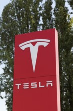 Tesla, pillar with logo in front of Tesla repair shop, US car manufacturer for electric cars,