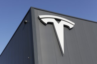 Tesla, logo on modern workshop building, figurative mark without lettering, US car manufacturer for