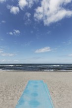Deserted beach with blue sand mat for barrier-free beach access, blue sky, Kühlungsborn, Baltic