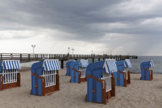 Pier and beach with closed beach chairs, rain clouds, Kühlungsborn, Baltic Sea, Mecklenburg-Western