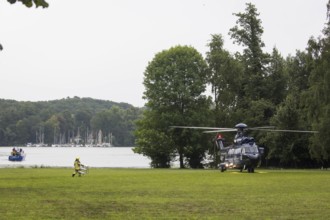 A firefighter transports a ladder to a helicopter in front of a joint meeting between Friedrich