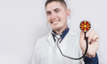 Doctor showing stethoscope with North Macedonia flag. North Macedonia national healthcare concept