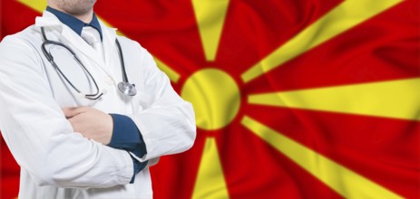 North Macedonia healthcare concept. Male doctor on North Macedonia flag. Doctor with crossed arms