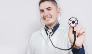 Doctor showing stethoscope with South Korea flag. South Korea national healthcare concept
