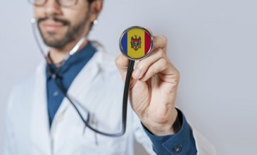 Doctor holding stethoscope with Moldova flag. Moldova health and care concept, Moldova flag on