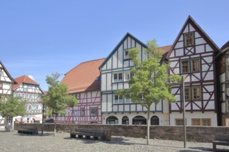 Colourful half-timbered houses, red, green, brown, empty benches, churchyard, Schmalkalden,