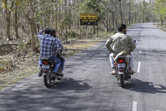 Motorcyclist in front of a Wildlife Corridor sign, Corbett National Park, near Ramnagar,