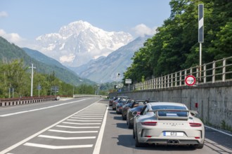 View of the highest mountain in the Alps Mont Blanc in the foreground several Porsche sports cars