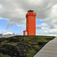 Orange lighthouse Skálasnagaviti or Svörtuloft with volcano Snaefell Snaefellsjökull glacier,