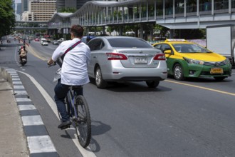Road traffic cyclists and cars, Bangkok, Thailand