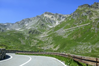 View of front curves of pass road mountain road alpine road above tree line, in the centre right in