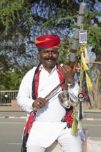 Indian man playing a long-necked spit lute or Ravanahattha, Udaipur, Rajasthan, India