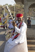 Indian man playing a long-necked spit lute or Ravanahattha at Lake Fateh Sagar, Udaipur, Rajasthan,