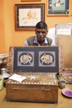 Miniature painter, 52 years old, shows a picture of the royal elephant in his studio, Udaipur,