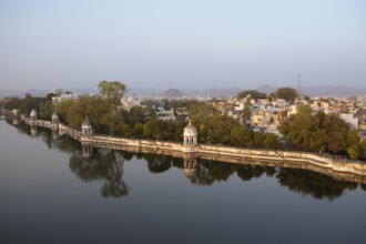Pagodas in Swaroop Sagar Garden at Swaroop Sagar Lake in evening light, the city in the background,