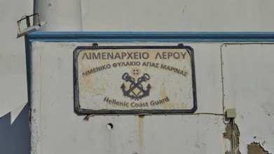 Worn sign of the Hellenic Coast Guard on a white wall, Agia Marina, Leros, Dodecanese, Greek