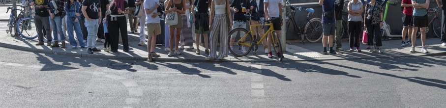 Passers-by waiting at a pedestrian crossing, Munich, Bavaria, Germany