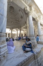 Indian woman praying between the white marble pillars in the Adinath temple in Ranakpur, Jain