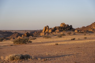 Barren landscape with hills of stacked rocks, desert landscape in the evening light at sunset,