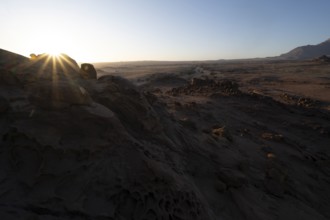 Eroded rock formations at sunrise with sun star, Erongo, Damaraland, Namibia