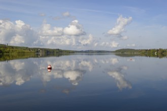 View over the Möhnesee, Möhnesee tower, red and white buoy, blue cloudy sky, reflection on the