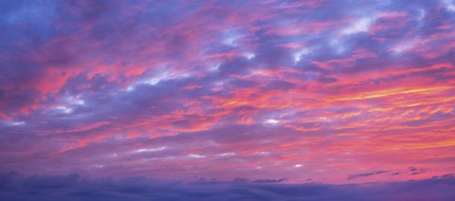 Background image for sky replacement, evening sky with illuminated red clouds at dusk after sunset