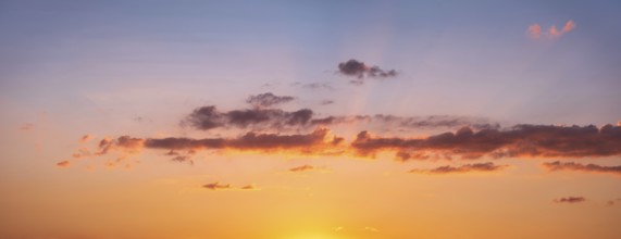 Wallpaper for sky replacement, evening sky with orange glowing clouds and sun rays at sunset