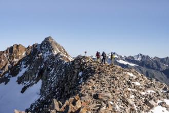 Mountaineer on a ridge, in the background summit Wilder Freiger with summit cross, Stubai Alps,