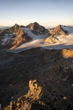 Picturesque high mountain landscape at sunrise with alpenglow, glacier and rocky mountain peaks in
