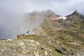 Mountaineer on a hiking trail, cloudy mountain landscape, Egetenjoch, Seven Lakes Hike, Stubai