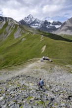 Mountaineer on hiking trail, Glorerhütte mountain hut and mountain peak in the background, Wiener