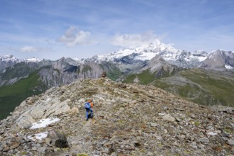 Mountaineer on a hiking trail, snow-covered and glaciated summit of the Großglockner in the