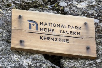 Wooden sign on rock, inscription Hohe Tauern National Park core zone, Schober group, Hohe Tauern