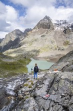 Mountaineer on a rocky hiking trail, view of the turquoise-blue mountain lake Großer Gradensee,