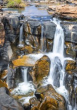 Waterfall on orange-coloured rock cliffs, long exposure, Blyde River, Bourke's Luck Potholes,
