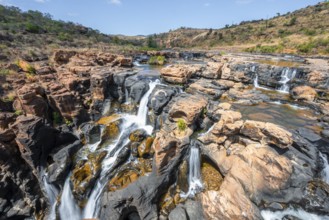 Waterfall on orange-coloured rock cliffs, long exposure, Blyde River, Bourke's Luck Potholes,