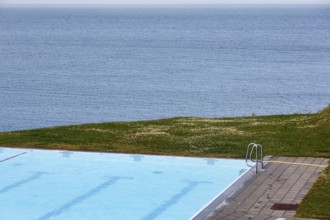 View from above of swimming pool by the sea, thermal bath, heated outdoor pool in Hofsos at the