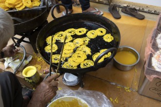 Indian man frying local sweet in the old town of Jaisalmer, Rajasthan, India